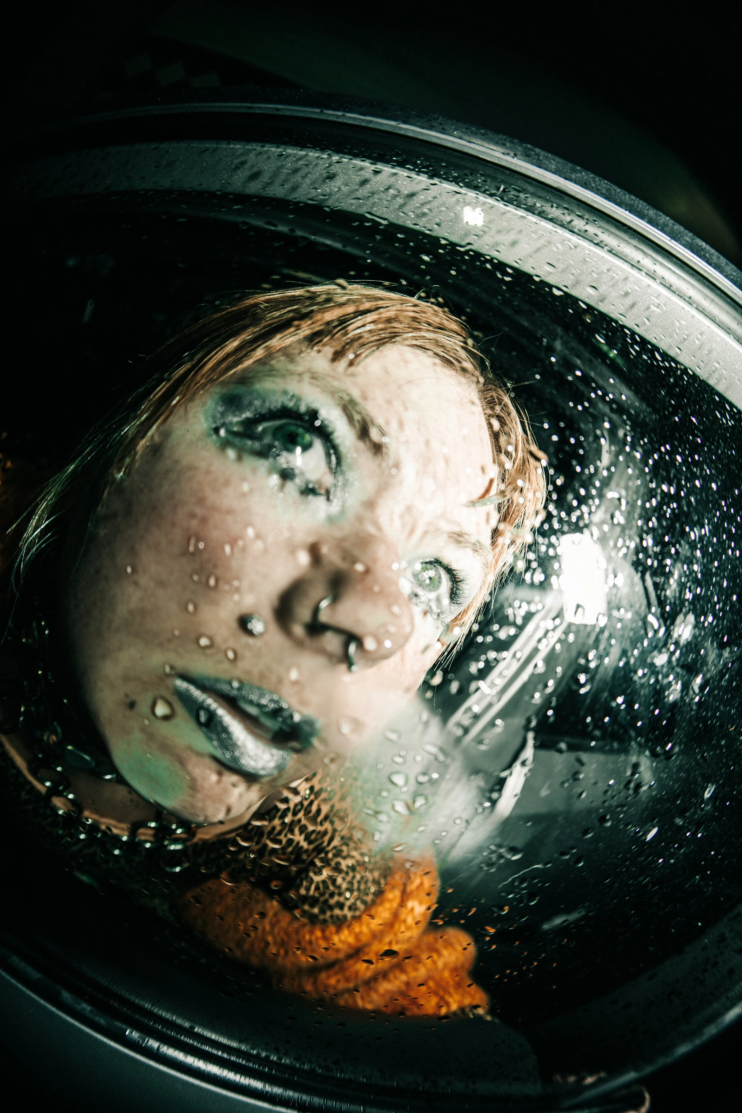 close up portrait through wet glass with water droplets, surreal editorial photography with reflective lighting