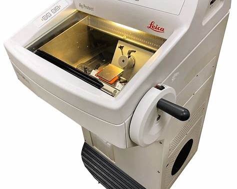 A laser engraving machine with a transparent lid, showing a small wooden block inside.