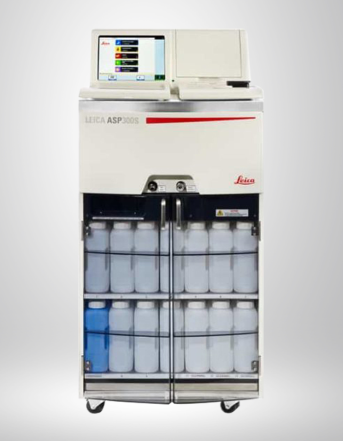 Leica ASP300S laboratory instrument with a digital touchscreen display on top, stored in a white metal cabinet with transparent doors showing multiple reagent containers inside, on a plain gray background.