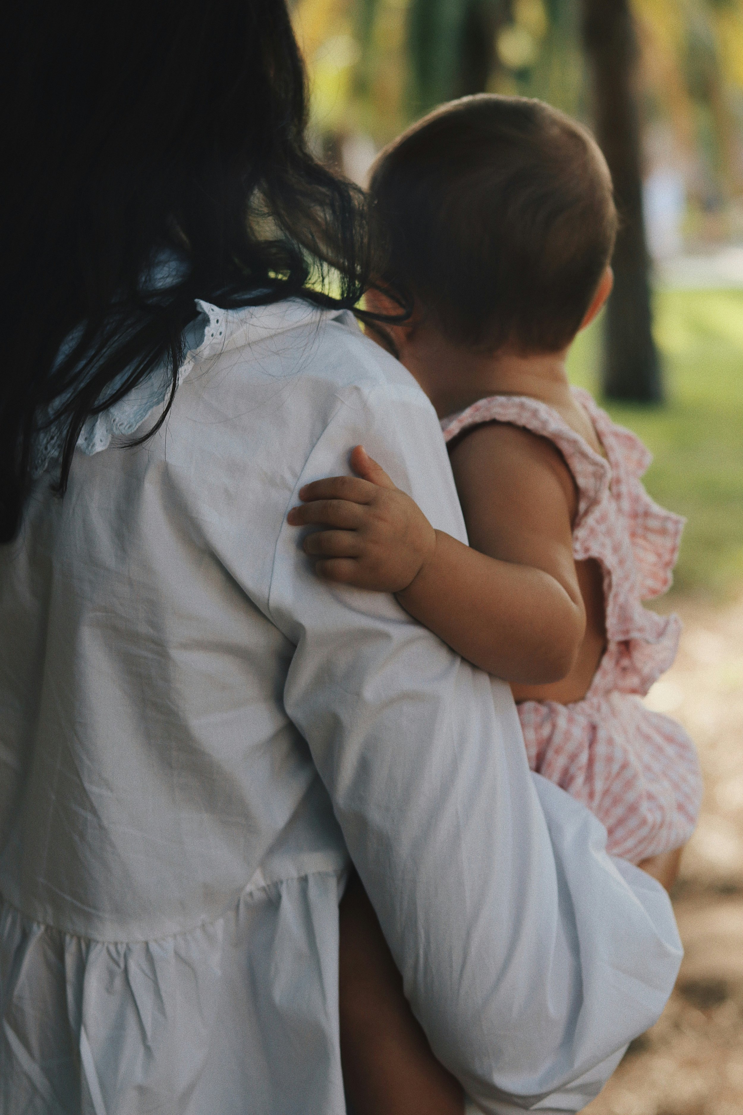 mom holding baby daughter outside in natural light