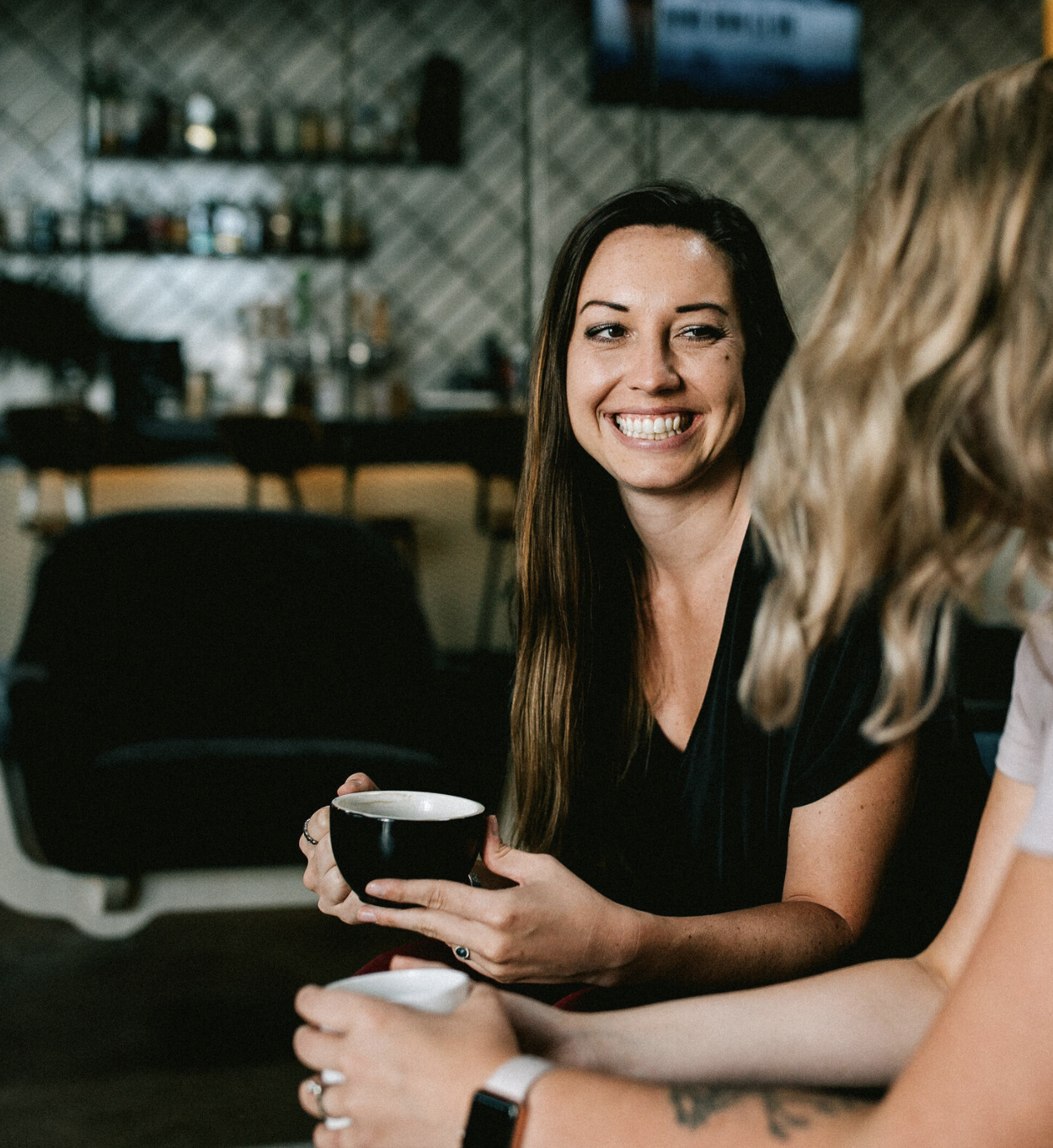 close up of deidre having a cup of coffee and conversation in a coffee shop