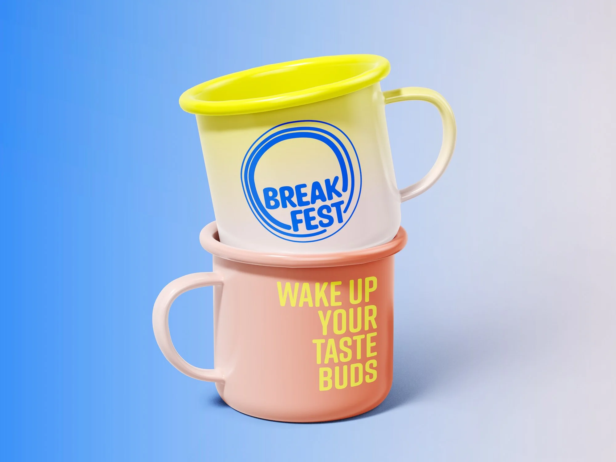 Two stacked colorful coffee mugs, one yellow with a blue 'BREAK FAST' logo, and one pink with yellow text 'WAKE UP YOUR TASTE BUDS,' against a light blue background.