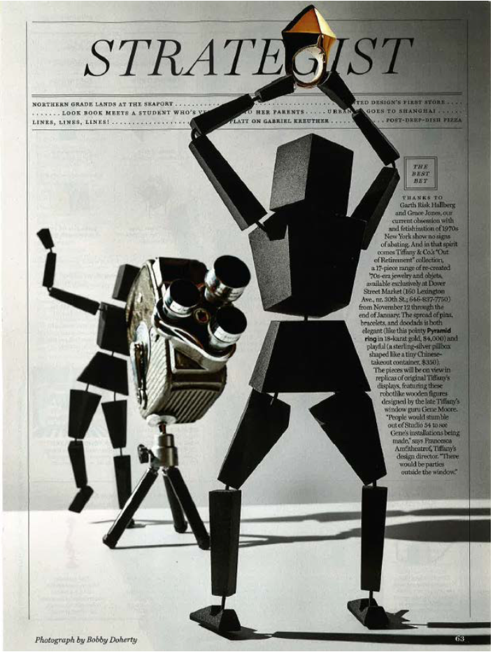 An artistic collage of a robot and a vintage movie camera, combined with a newspaper background featuring the title "STRATEGIST." The robot appears to be lifting a gold trophy above its head, with its body made of blocky black shapes.