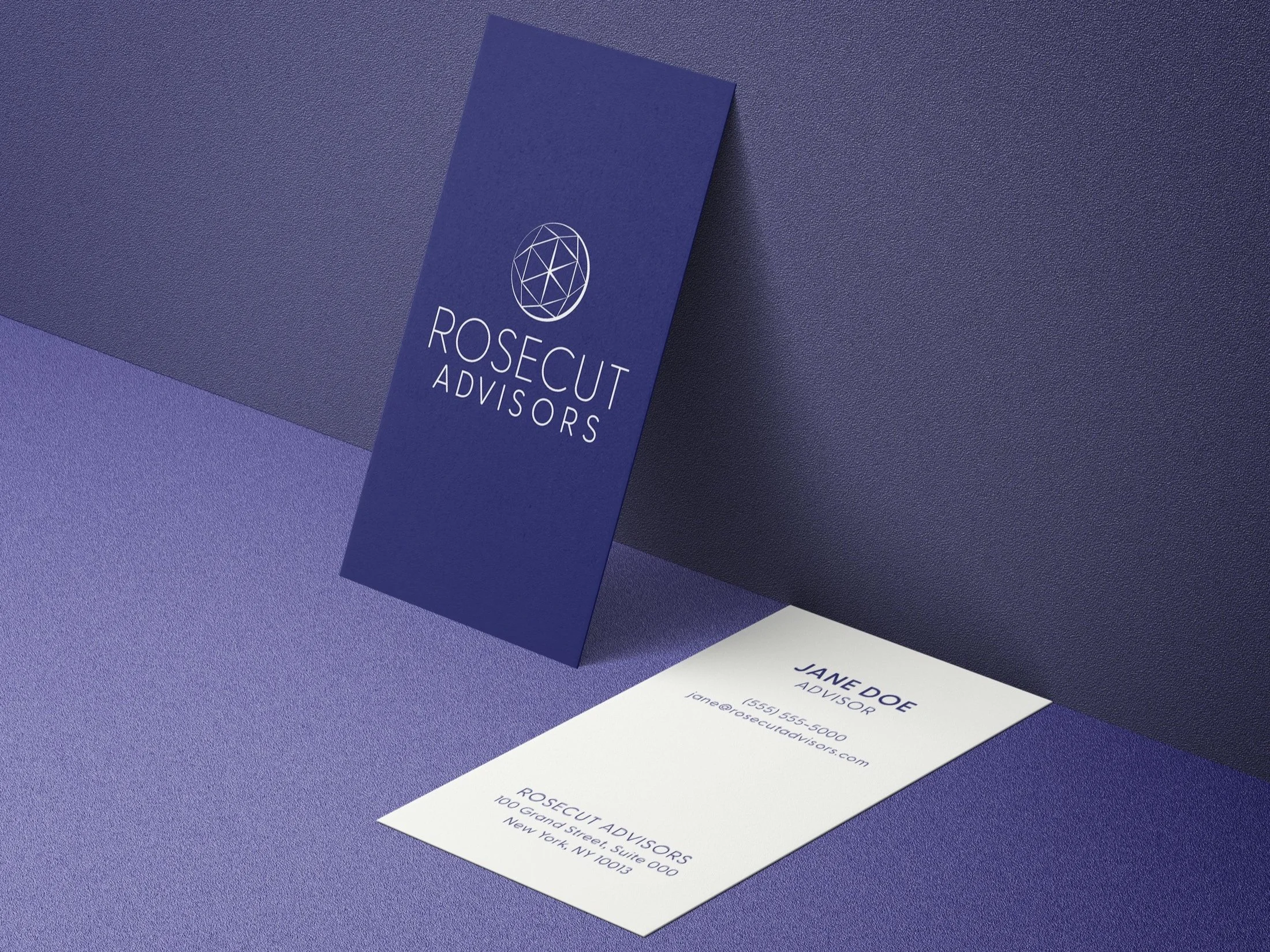A business card and a vertical folder with the logo and name "ROSECUT ADVISORS" on a textured purple surface. The business card displays the name "JANE DOE", title "ADVISOR", contact information, and company address.