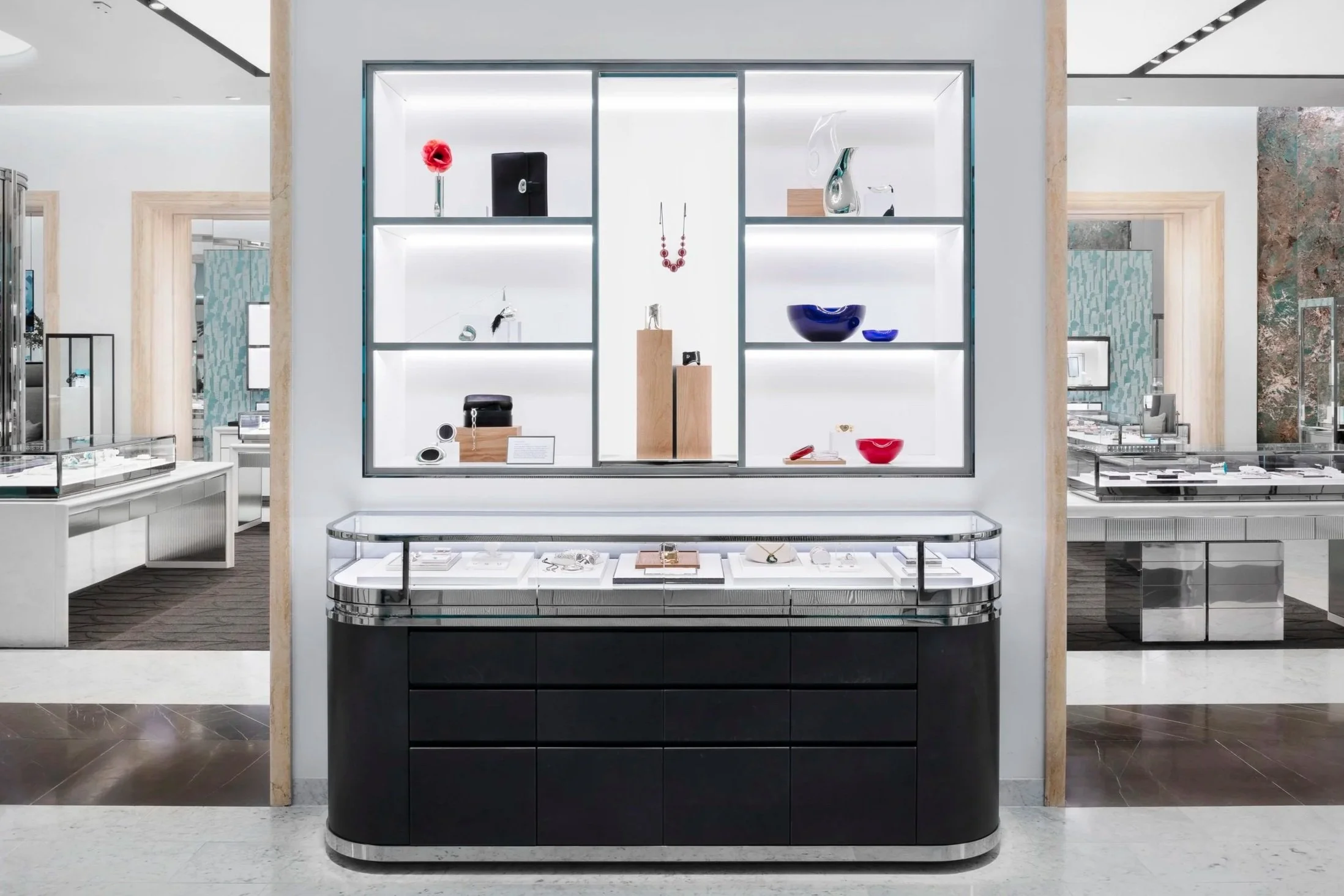 Jewelry display case in a modern store with glass shelves and jewelry pieces inside.