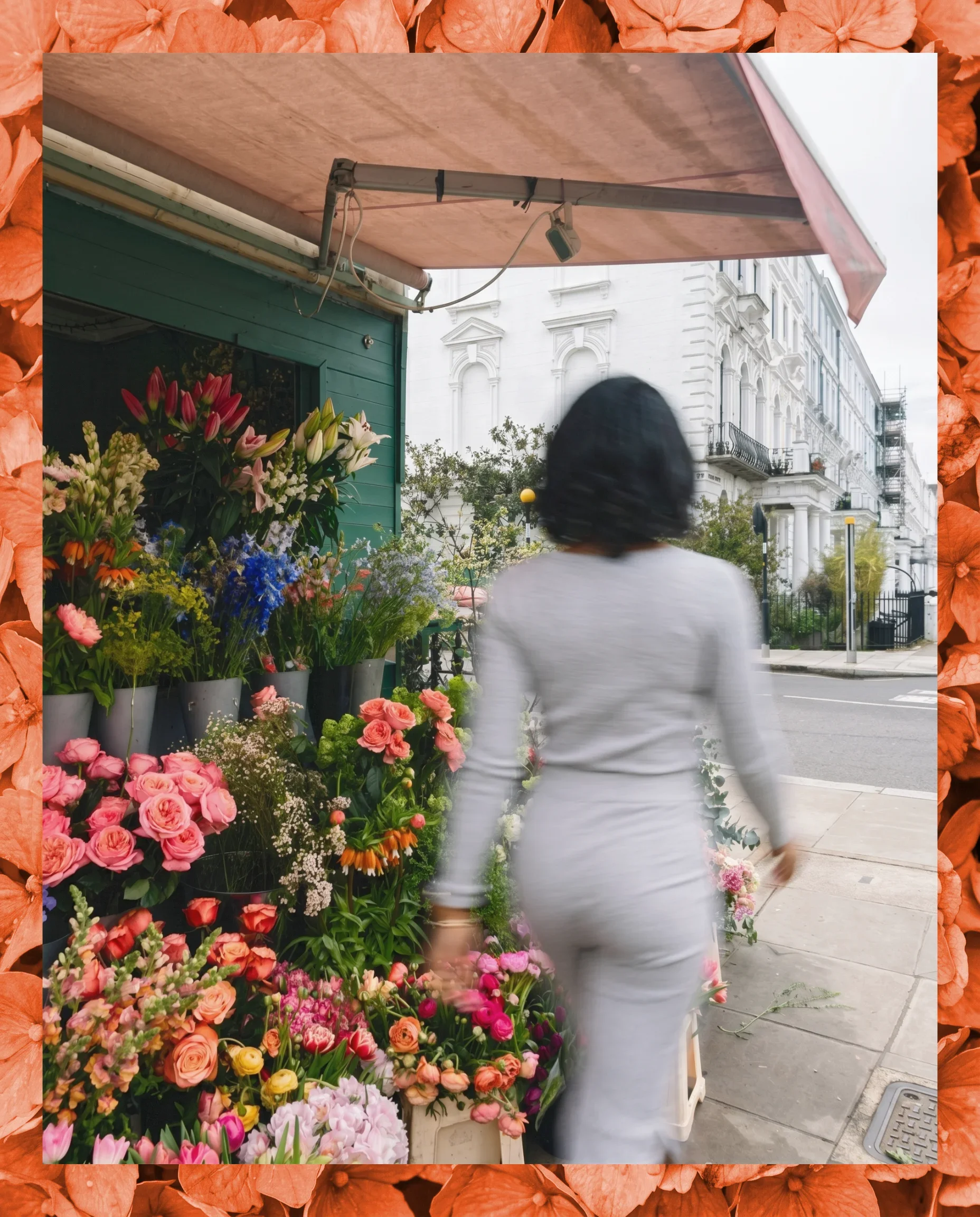 A woman walking past a flower shop with an array of colorful flowers outside, on a city street.