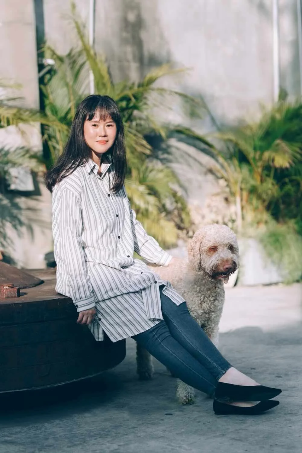 FuFan Chiang, LMFT, a licensed New York and Utah emdr therapist, smiling while sitting outdoors with her dog calmly, for Harmony Counseling.