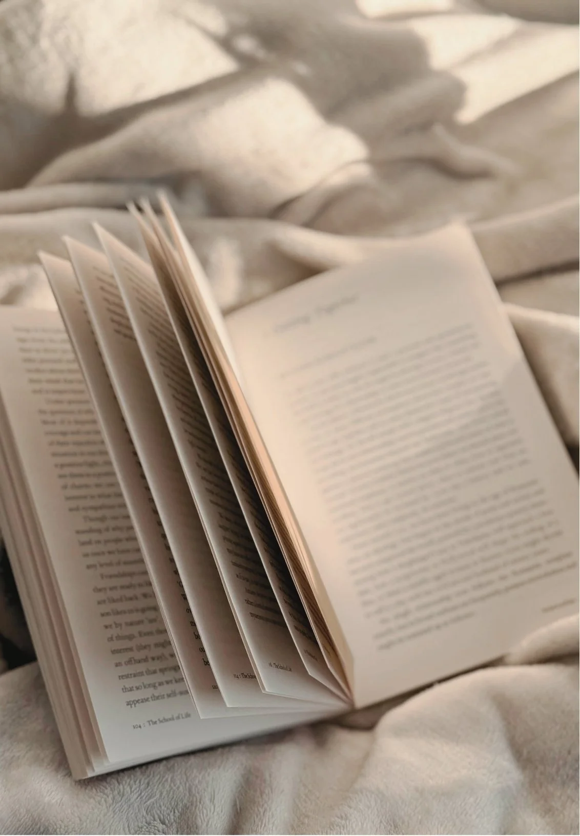 Open book resting on soft, light-colored fabric.