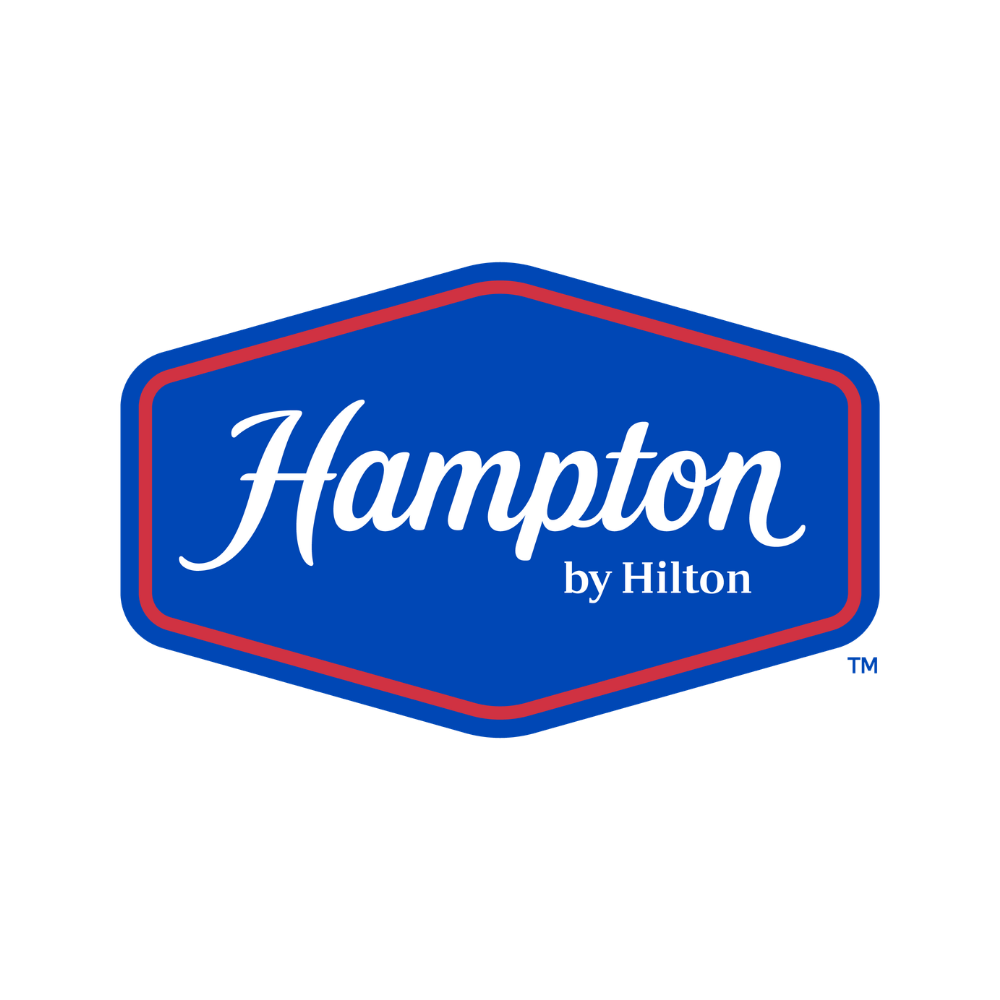 Hampton by Hilton hotel logo in blue with white and red accents.