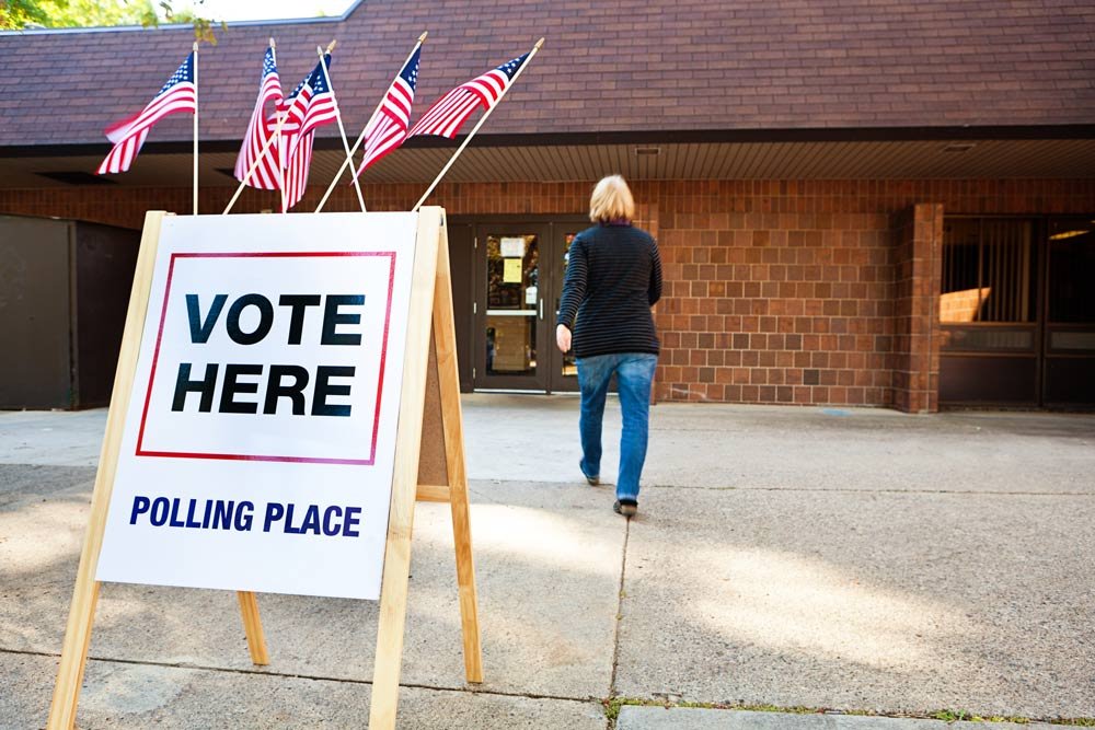 Person walks into a polling place marked vote here.