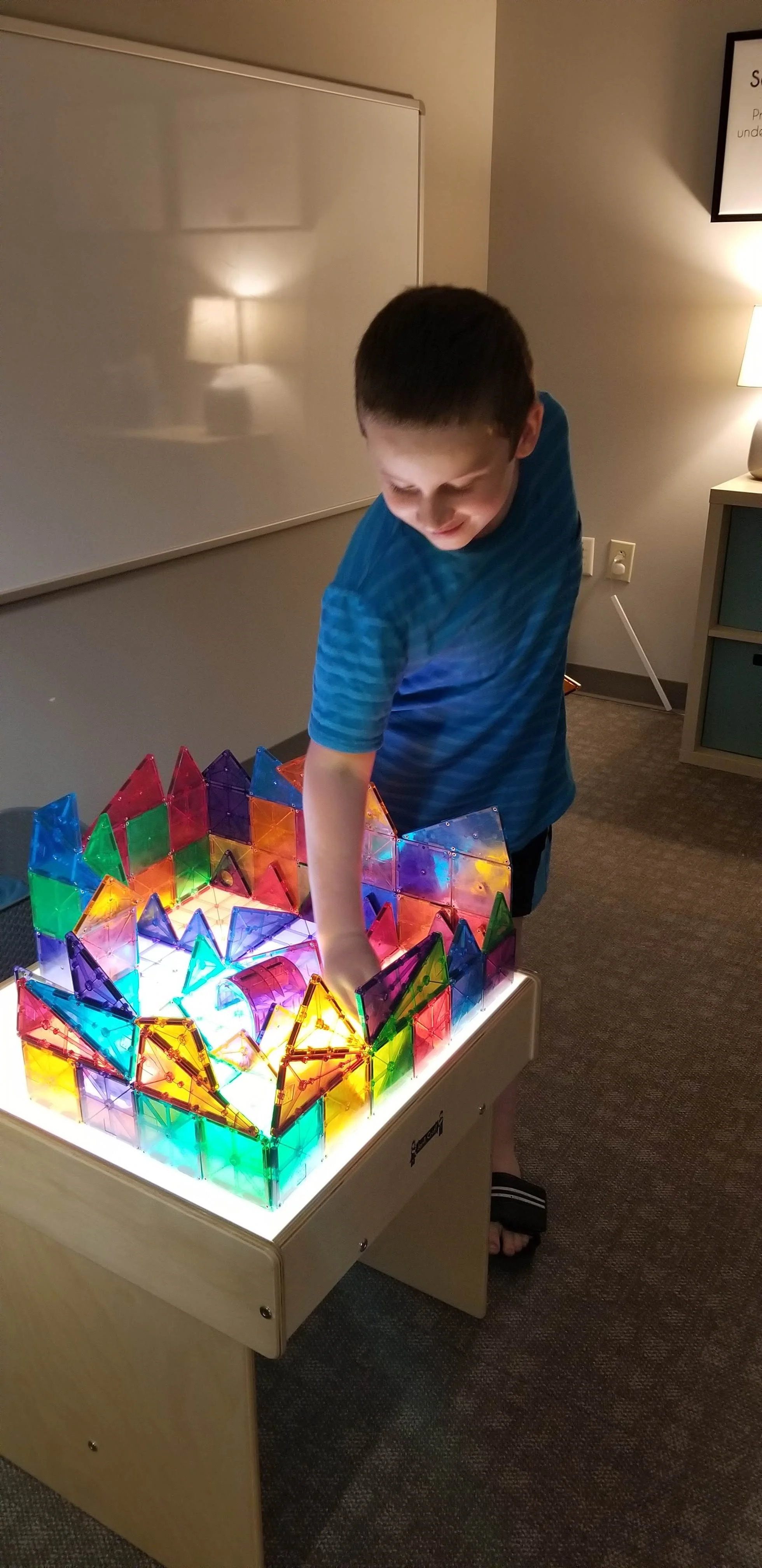 A boy playing with magnatiles