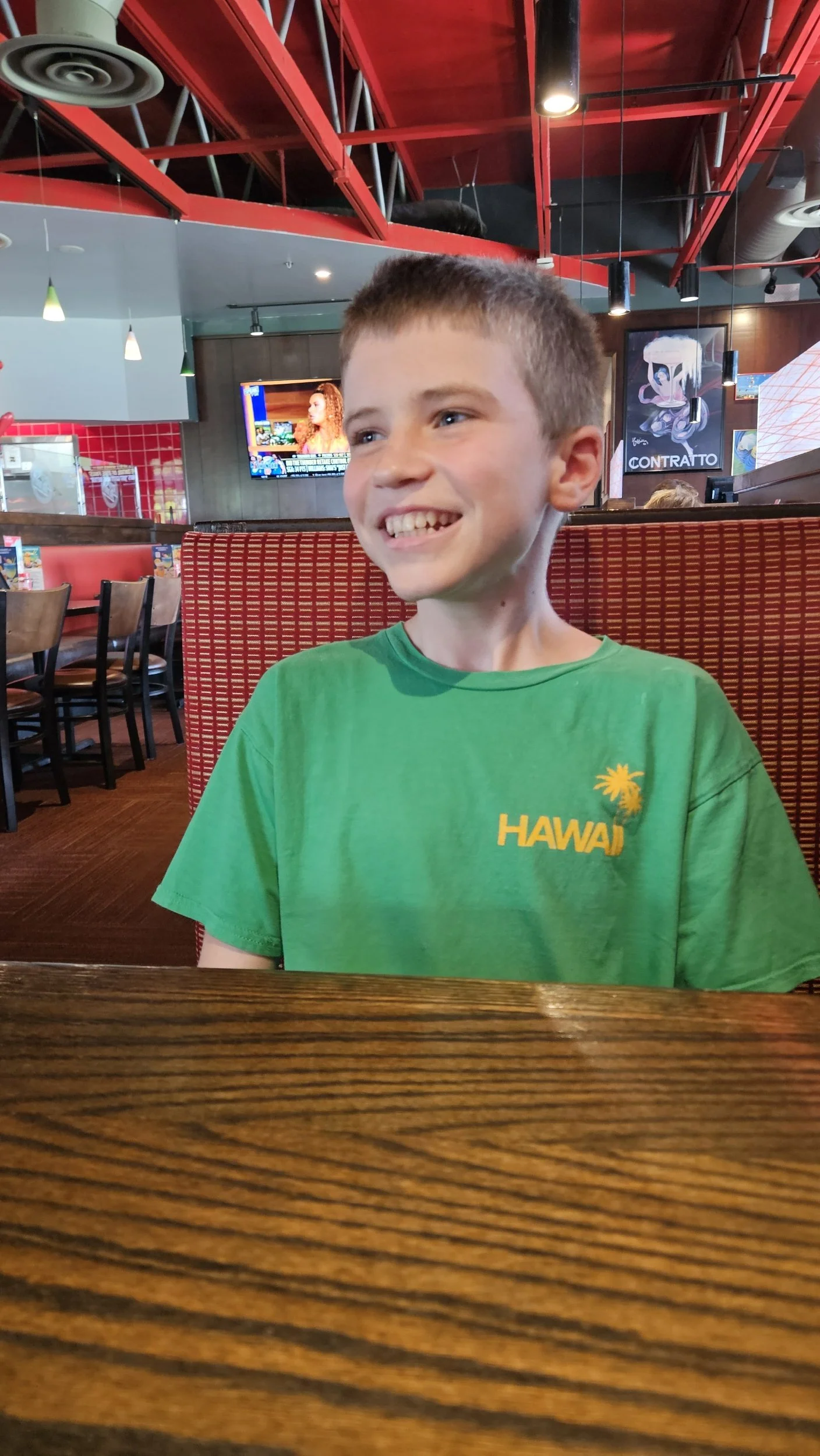 A boy is smiling while out for a community session at a restaurant