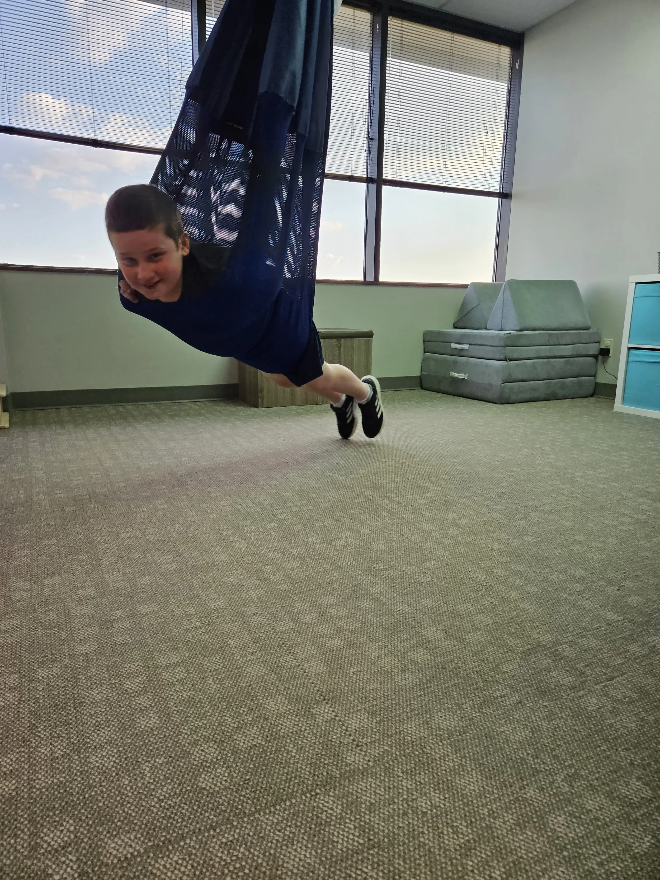 A boy swinging in a lycra swing.