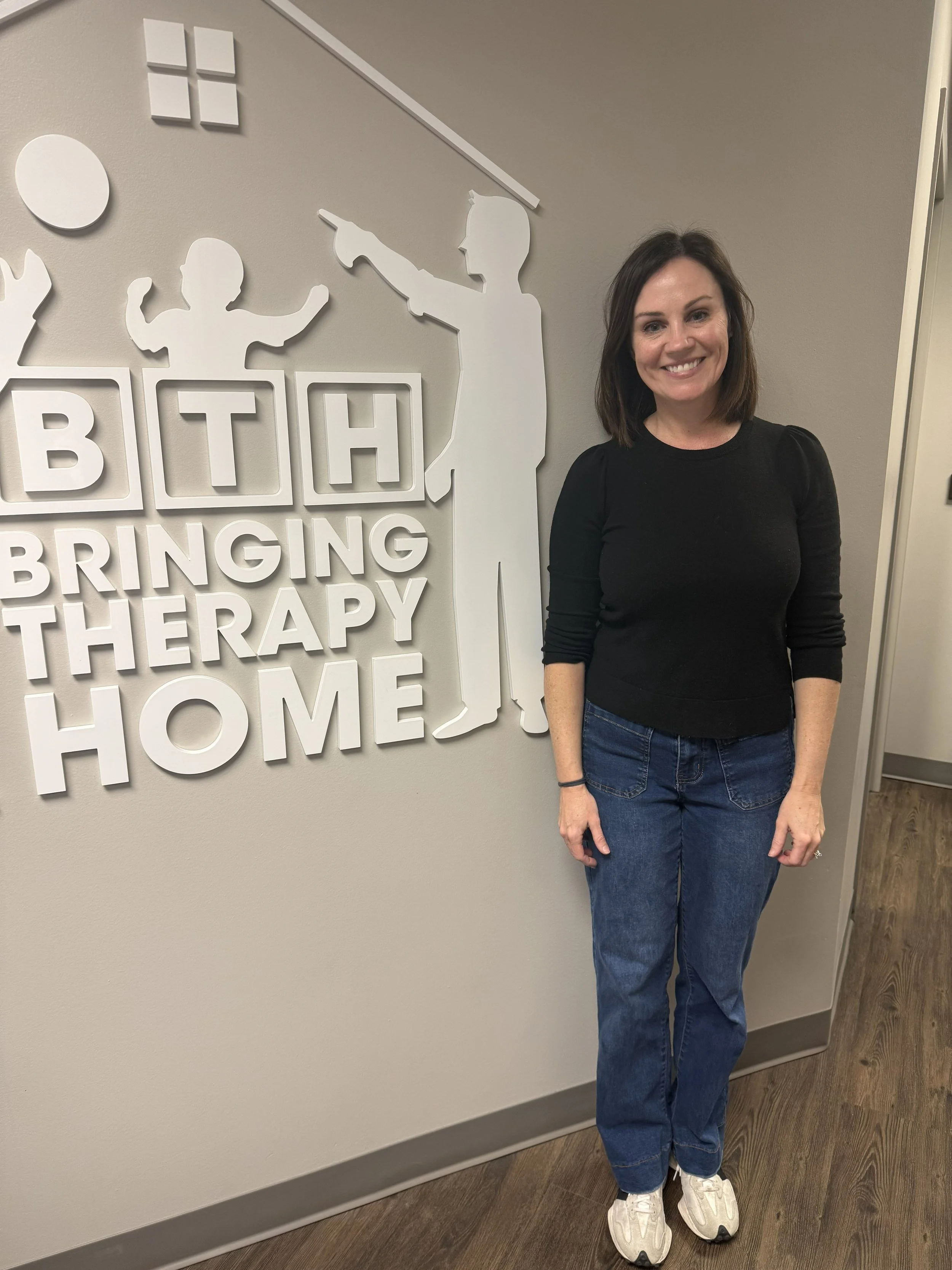Julie Morrow standing in front of the BTH Logo
