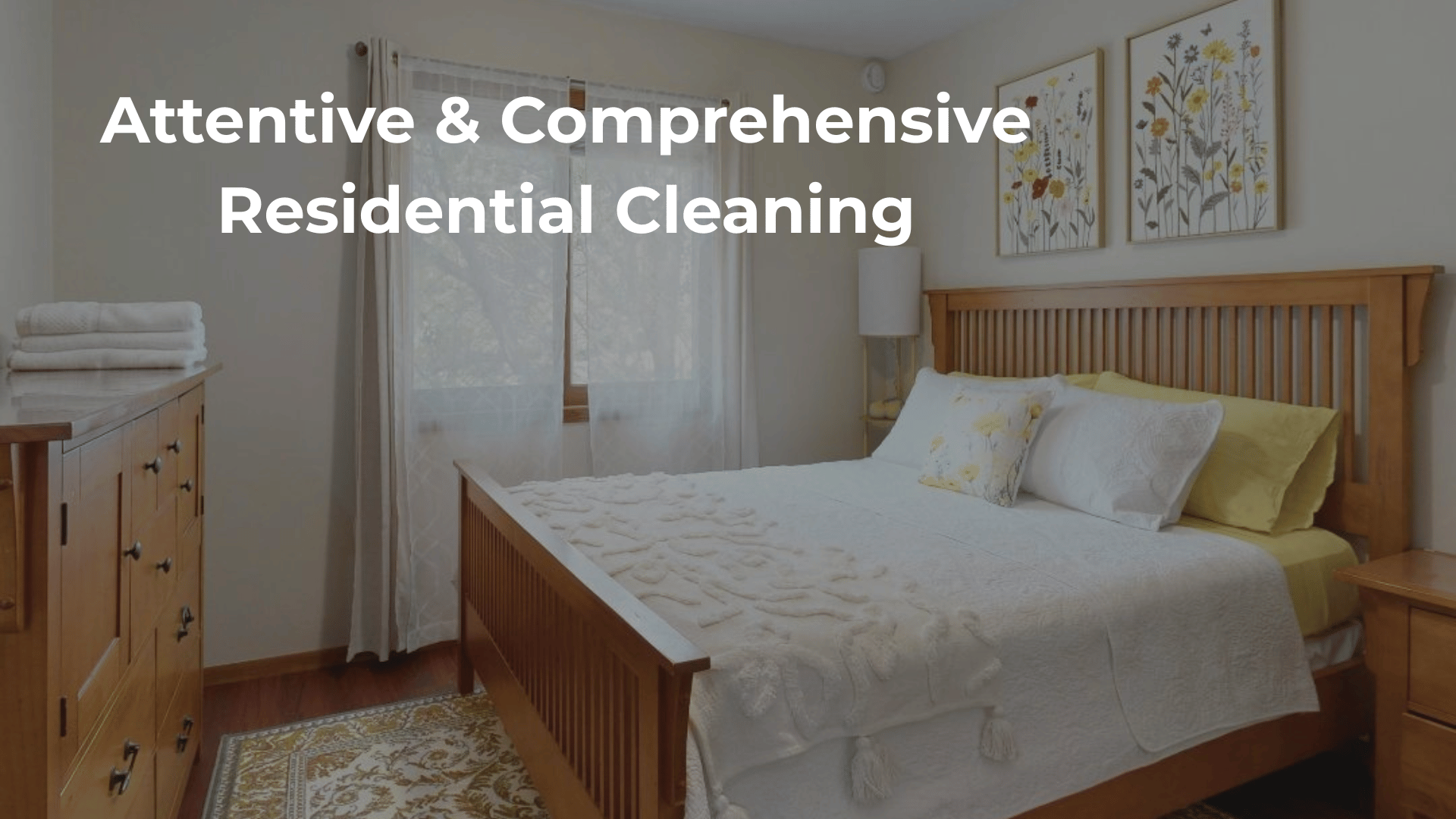 A clean and cozy bedroom with wooden furniture, a bed with white bedding and pillows, a window with sheer curtains, and framed floral artwork on the wall.