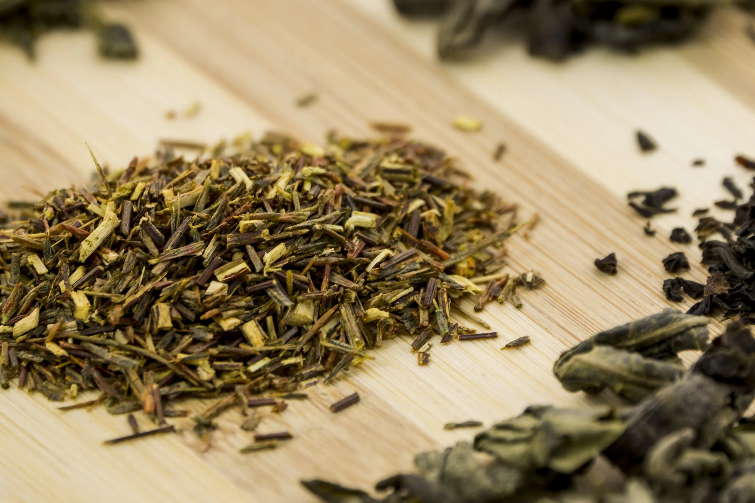 A close-up view of dried herbal or tea leaves on a wooden surface.