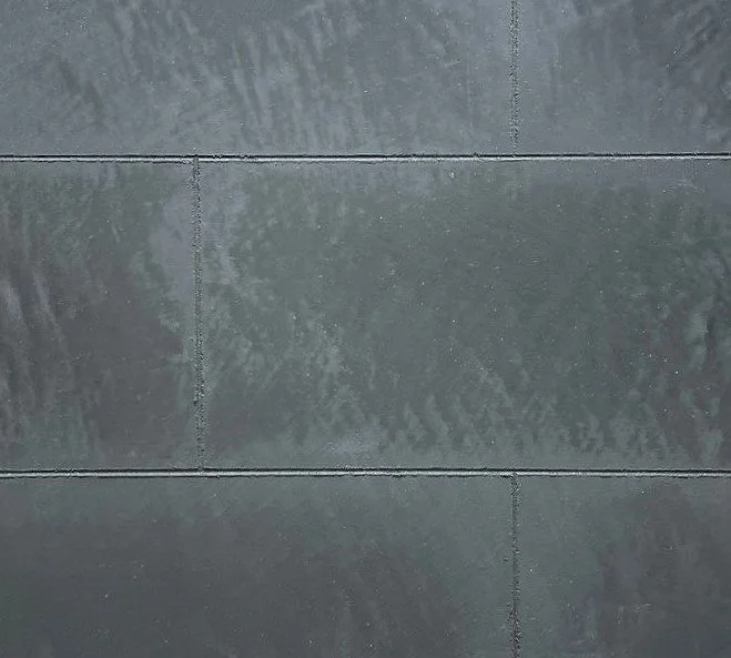 Close-up of gray tiled wall with textured pattern and visible grout lines