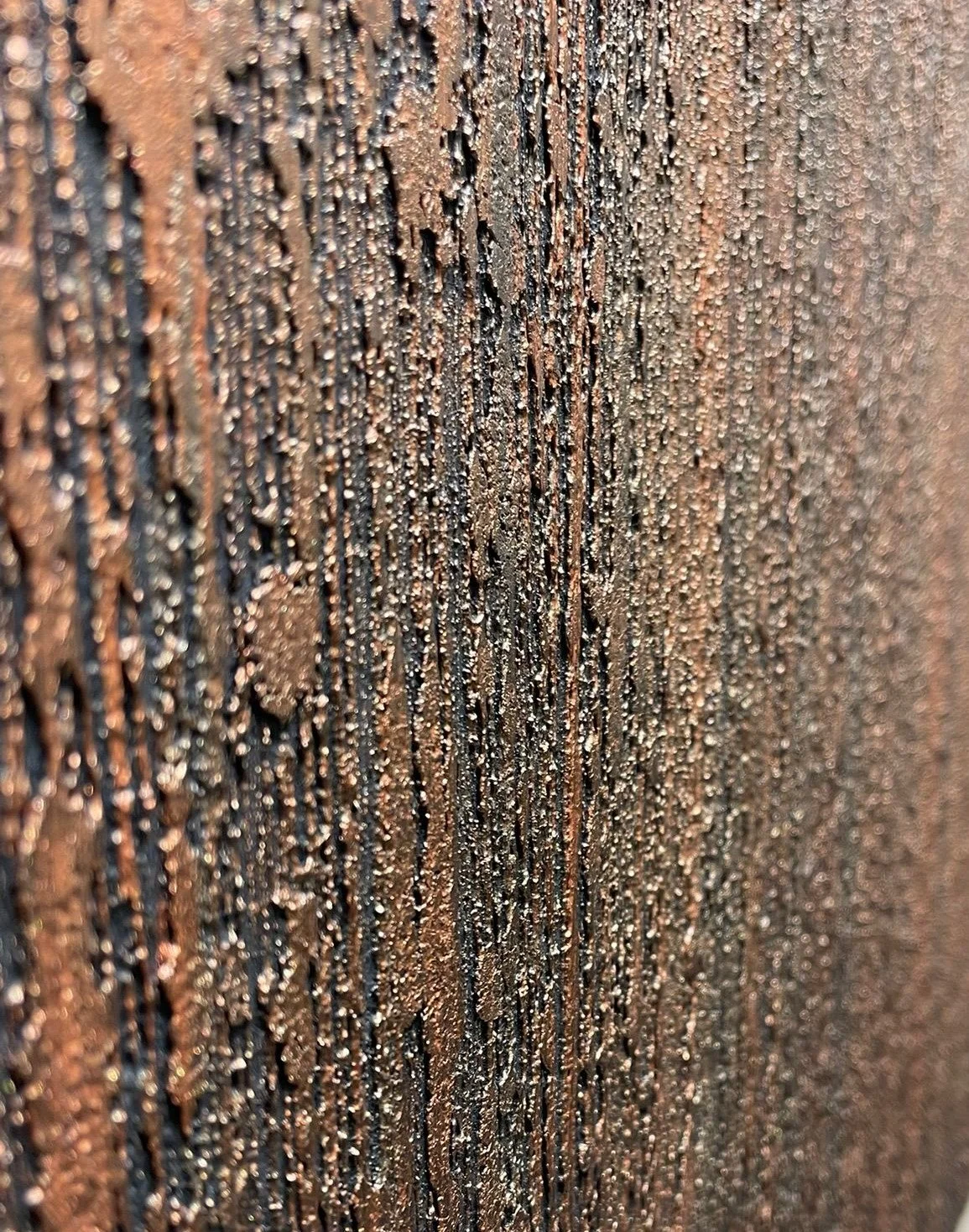 Close-up of a wooden surface with water droplets on it, highlighting the texture and grain of the wood.