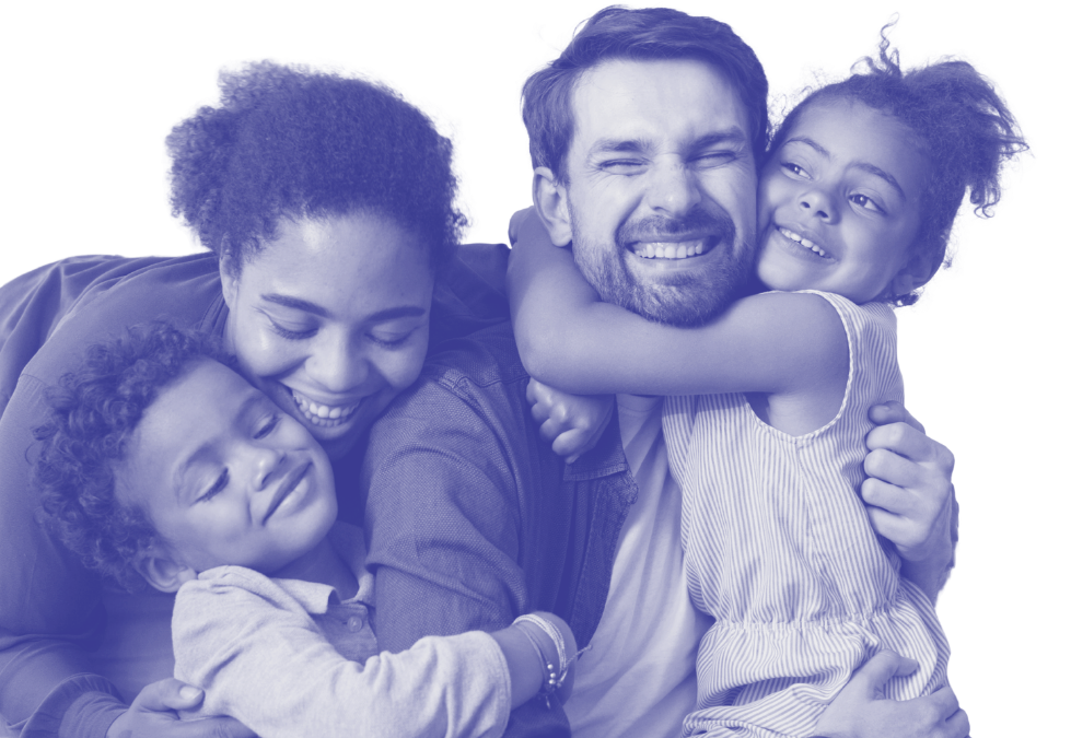 Happy family of four hugging and smiling, embracing each other tightly.