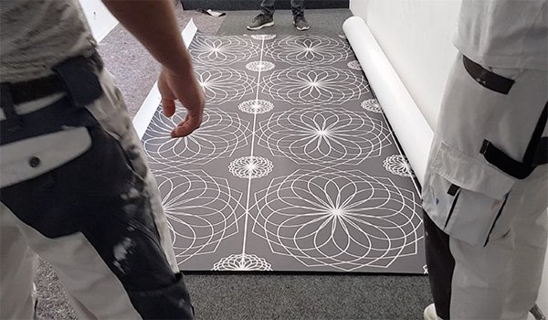 3. Poster ausrollen und Qualität prüfen.

Poster auf sauberem Untergrund auslegen und Druck sowie Material prüfen.
Bei langen Wänden Poster wieder locker aufrollen und Hülse entfernen.
Wichtiger Hinweis zur Materialprüfung!
Bitte prüfen Sie Material,