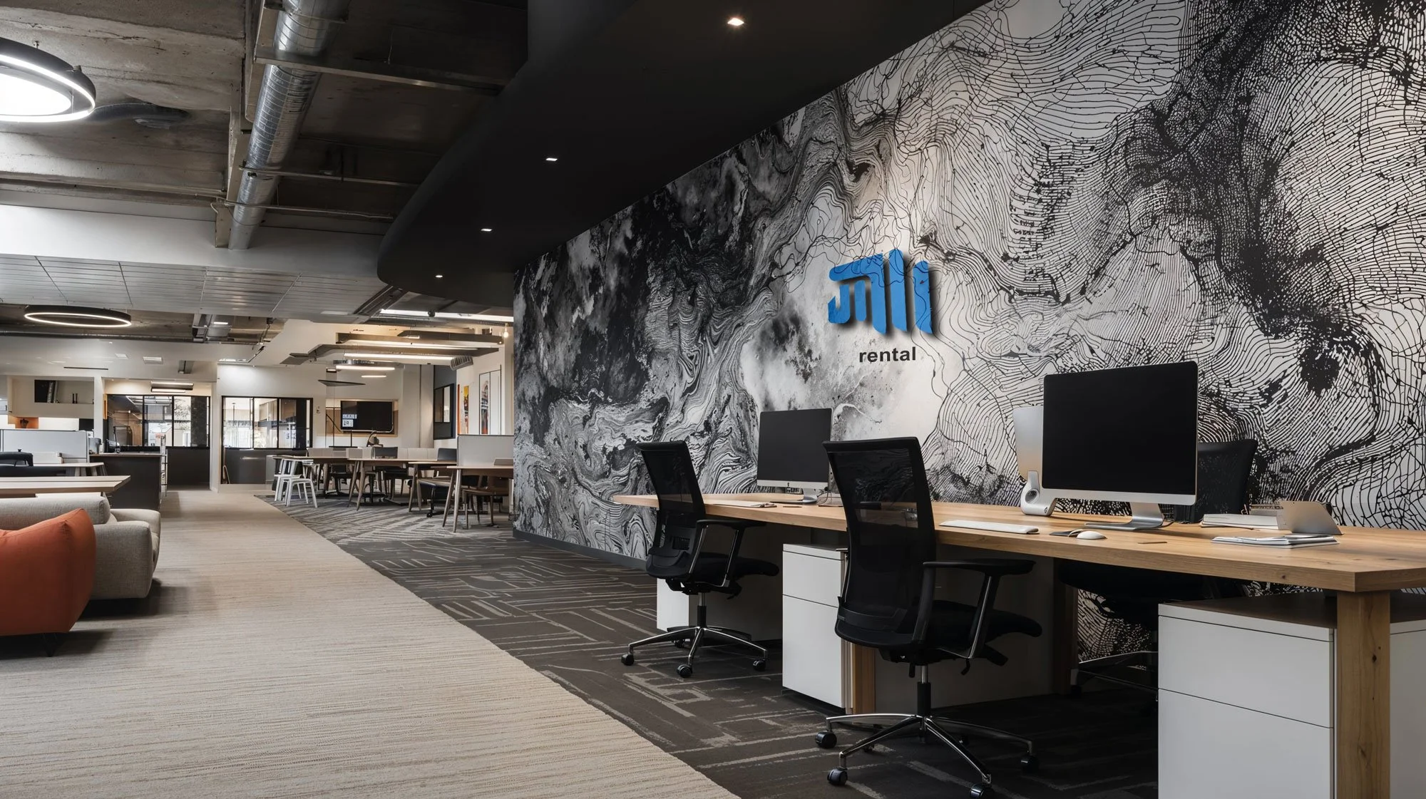 Modernes Büro mit höhenverstellbaren Schreibtischen, Computern und einem dekorativen Wandbild mit einem Firmenlogo auf einer schwarzen und weißen Wand, die offene Arbeitsbereiche zeigt.