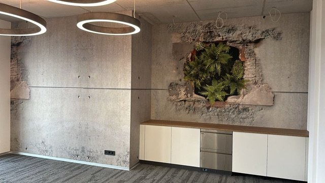 Moderne Wohnung mit einer Wand, in der eine große offene Stelle mit Pflanzen im Mauerwerk sichtbar ist, und zwei kreisförmige Deckenleuchten.