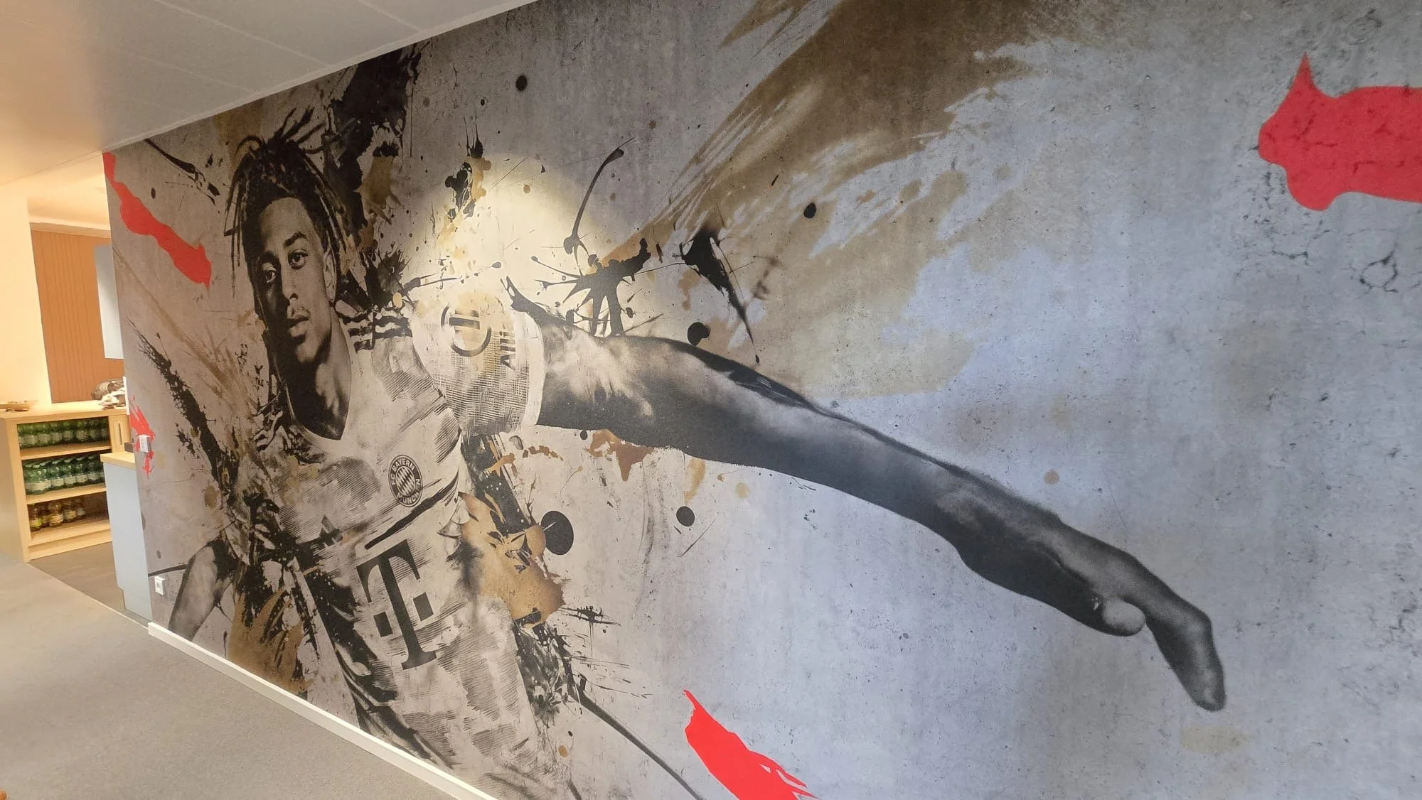 Wandbild einer Fußballspielerin in Aktion, Schwarz-Weiß mit Farbakzenten, künstlerischer Stil