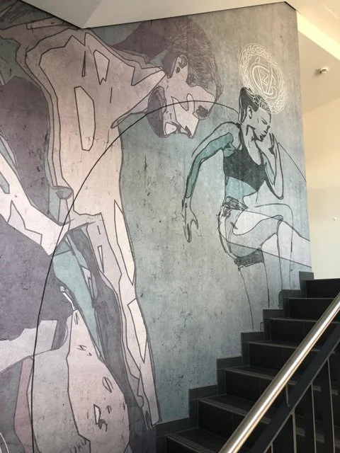 Graffiti an einer Treppenwand zeigt einen Fahrradfahrer und eine Frau, die in der Nähe sitzt.