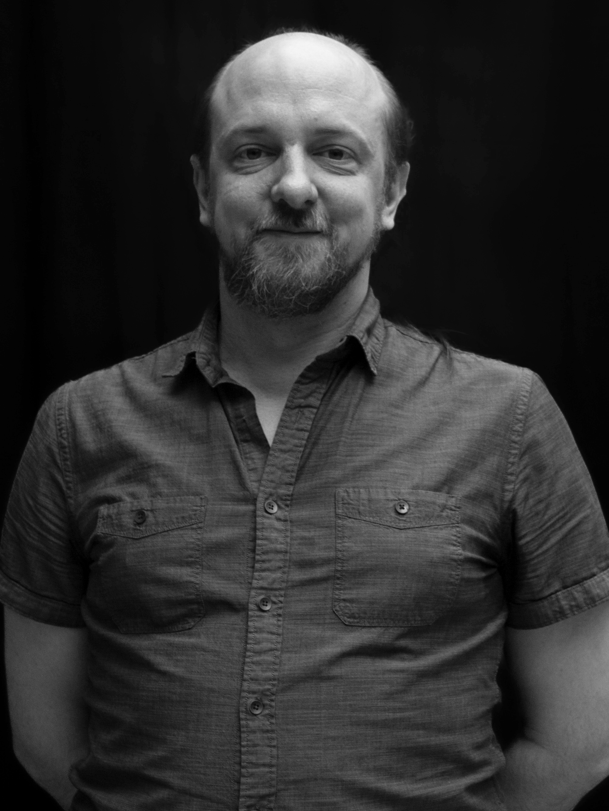 A black and white image of actor Jamie Loughead from the shoulders up
