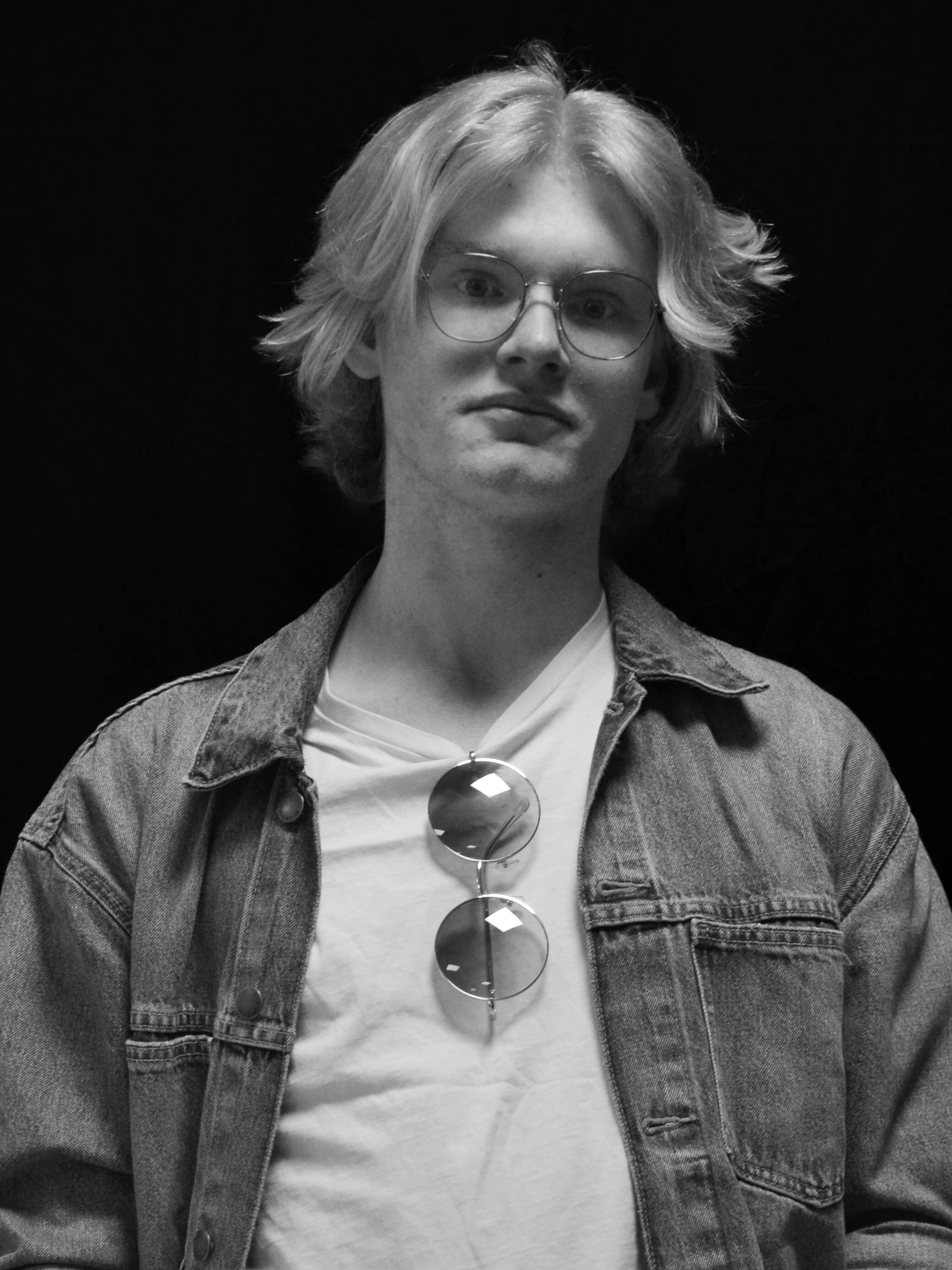 A black and white image of actor Aaron Caines from the shoulders up