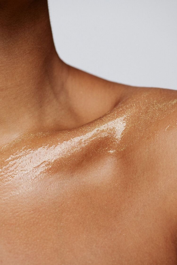 Pelle abbronzata con brillantini e una linea di polvere bianca sulla spalla