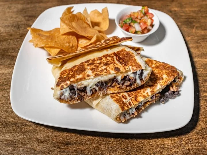Beef and bean quesadilla with chips and salsa on a white plate