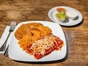 Plate with breaded fried chicken, rice, and a serving of red pasta sauce. Small bowl with salad and dressing on the side.