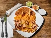 A plate with fried chicken, mashed potatoes with brown gravy, and a biscuit, with side dishes of green beans, butter, and sour cream.