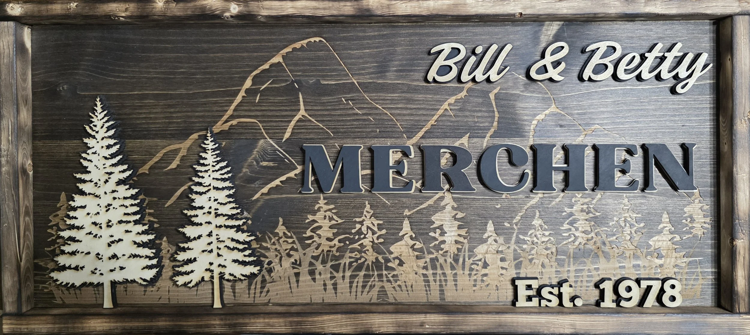 Personalized family name wood sign featuring rustic hills, mountain and forest design. Handmade well decor perfect for Airbnb, wedding, anniversaries, or housewarming gifts.
