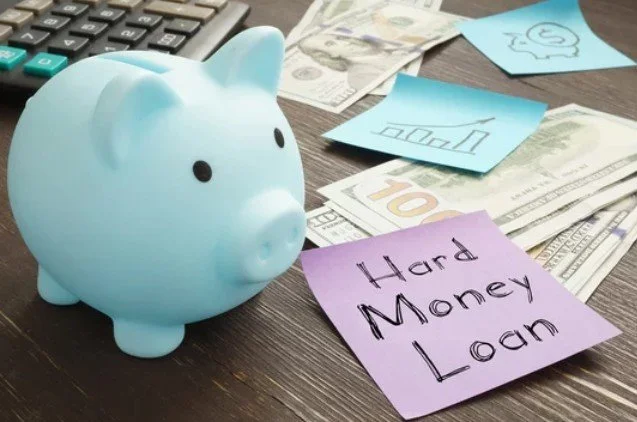 Blue piggy bank surrounded by dollar bills, ten dollar bill, and colorful sticky notes with financial notes, on a wooden surface.