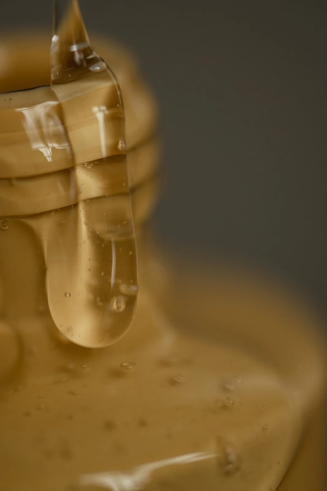 Close-up of a glass of iced coffee with ice cubes, showing condensation on the glass and a dark background.