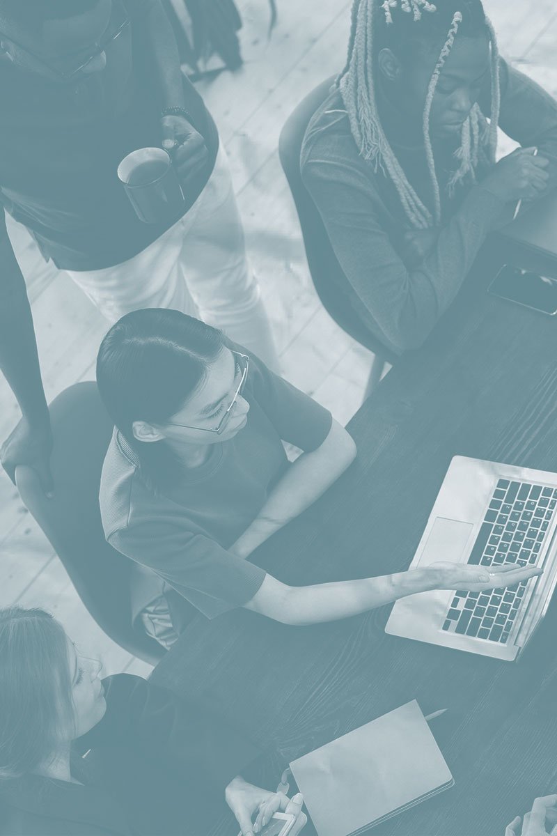 nonprofit shared services team looking at laptop together at conference table