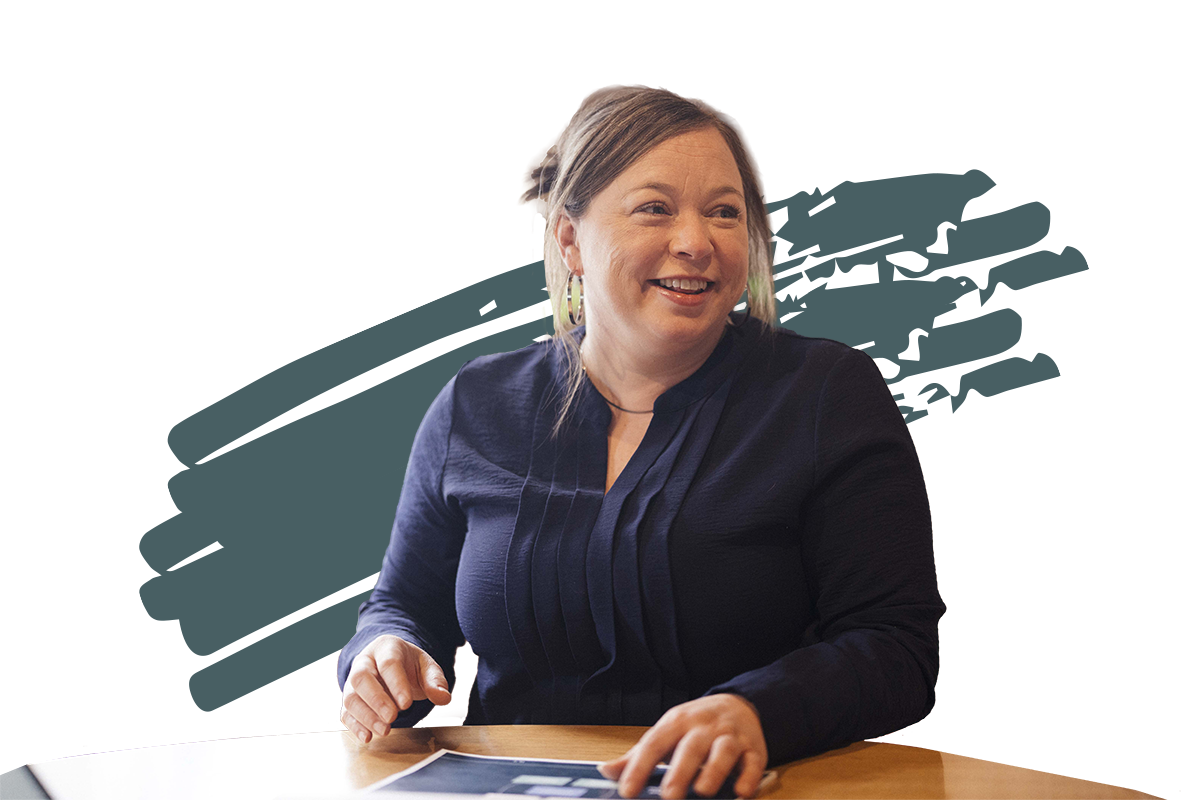 member of Keystone shared back office services team sitting at table and smiling at colleague off screen