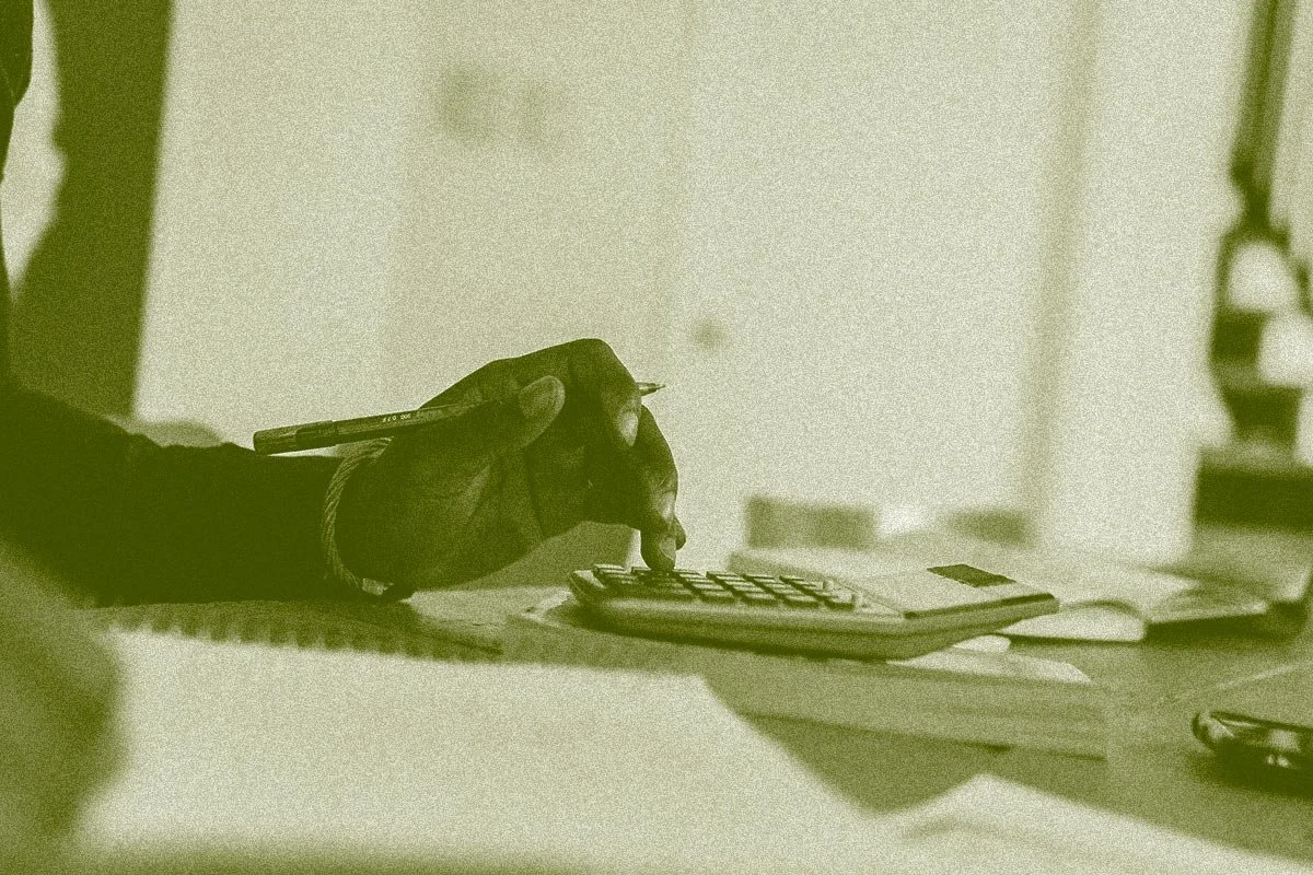 hand on calculator, nonprofit leader working on financial plan