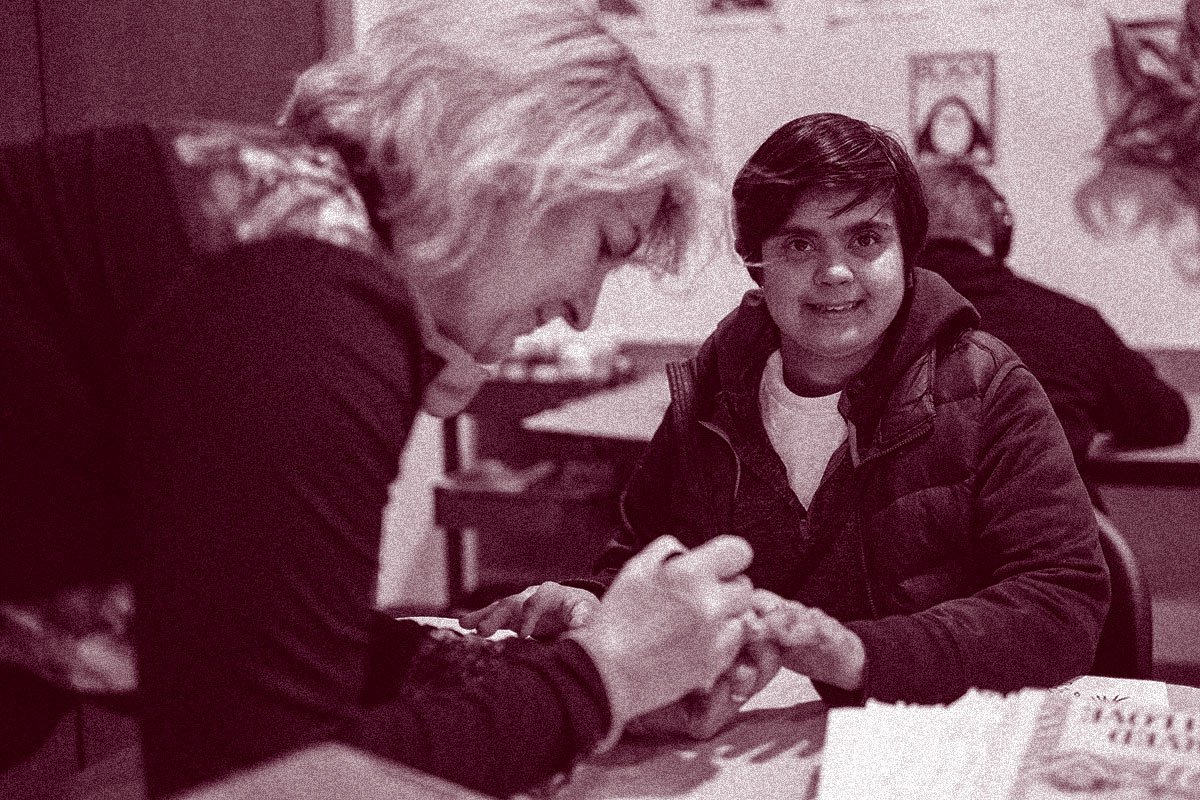 caregiver painting woman's nails at Search360 day program for adults with I/DD