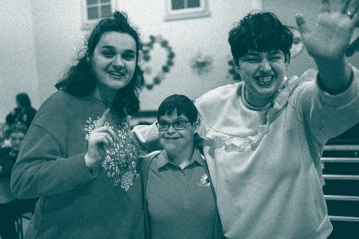three participants of a Search360 program for adults with i/DD smiling at camera