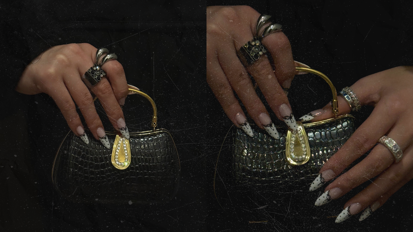 A woman with long, polkadot, decorated nails holds a black, crocodile-embossed handbag with gold accents and a teardrop-shaped clasp. She wears multiple rings on her fingers, including one with large, black stones.