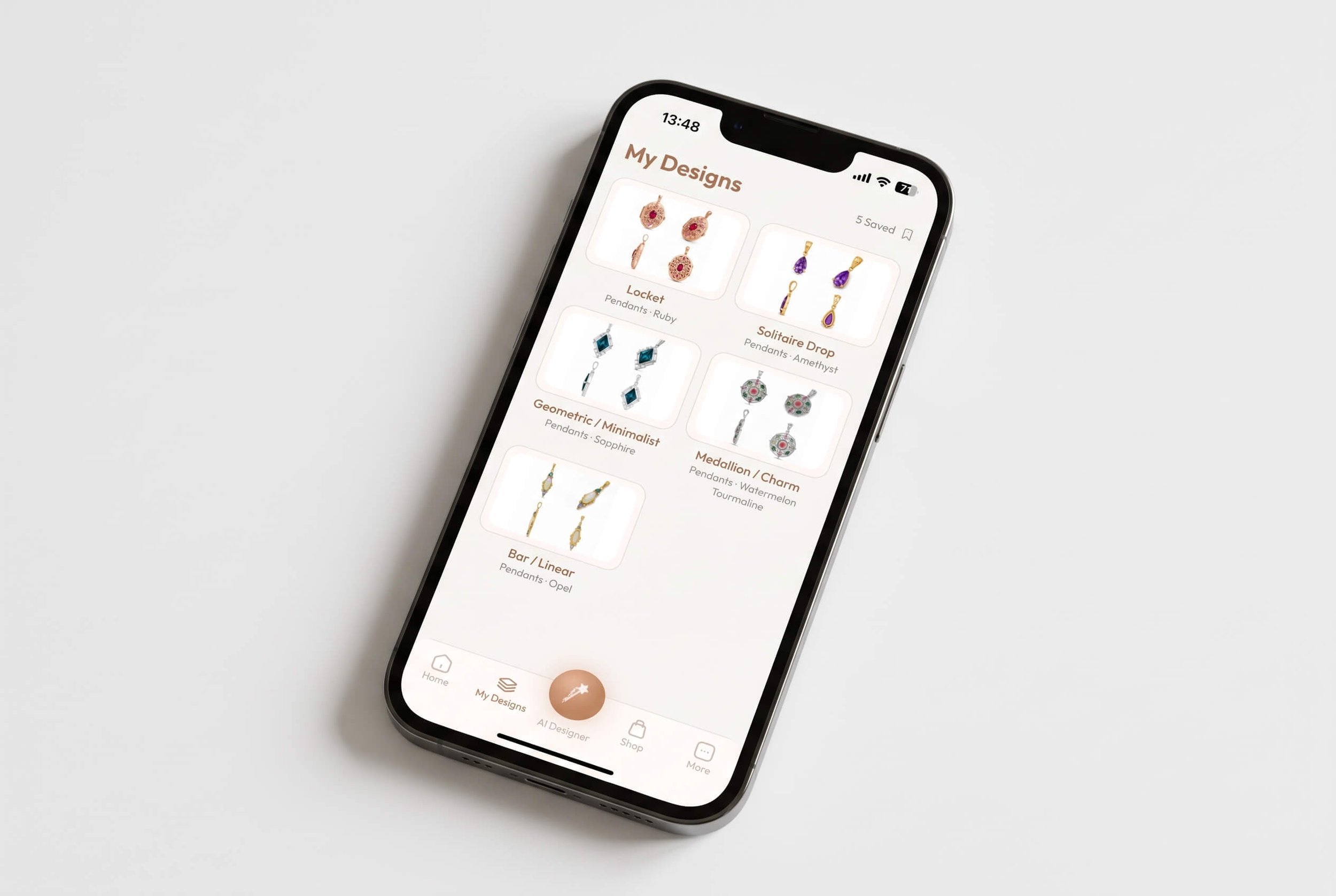 Phone on a white surface showing a jewelry app's My Designs screen with five saved pendant styles