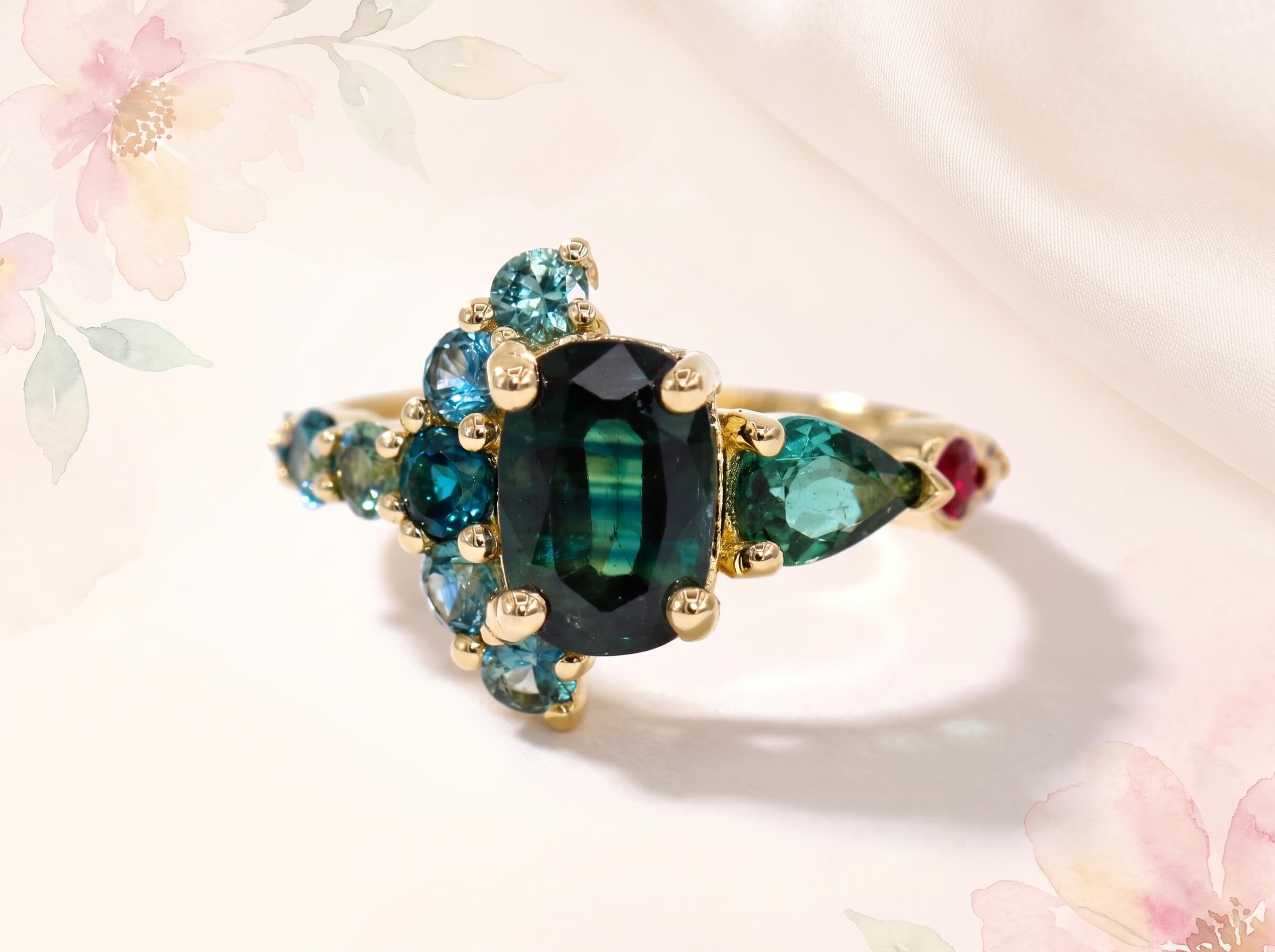 Four gemstone rings in rose and white gold with mint, green and pink centre stones on a beige backdrop
