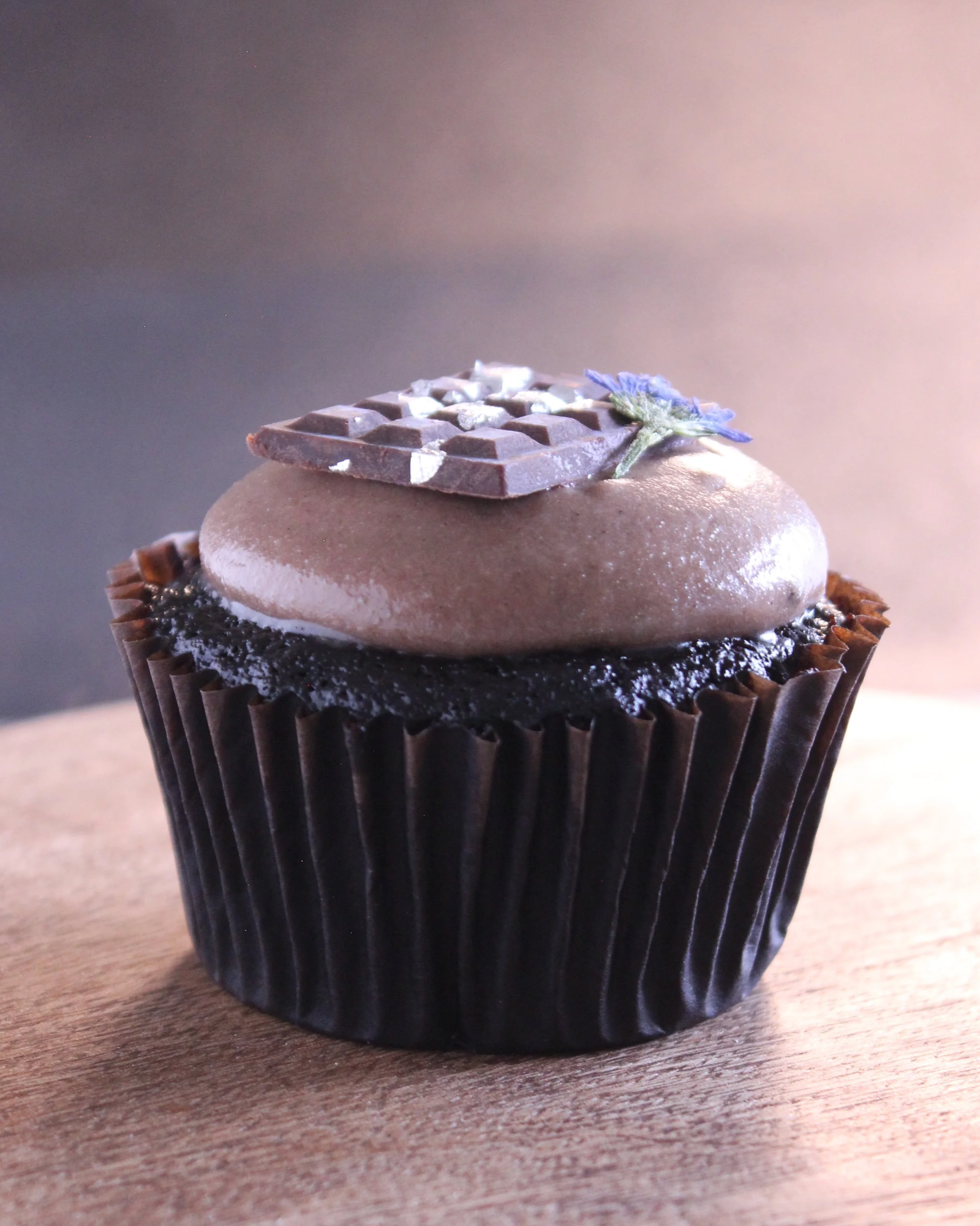 The Reaper: Triple chocolate indulgence with chocolate cake, dark chocolate buttercream, and a rich chocolate ganache filling. Topped with a mini chocolate bar.