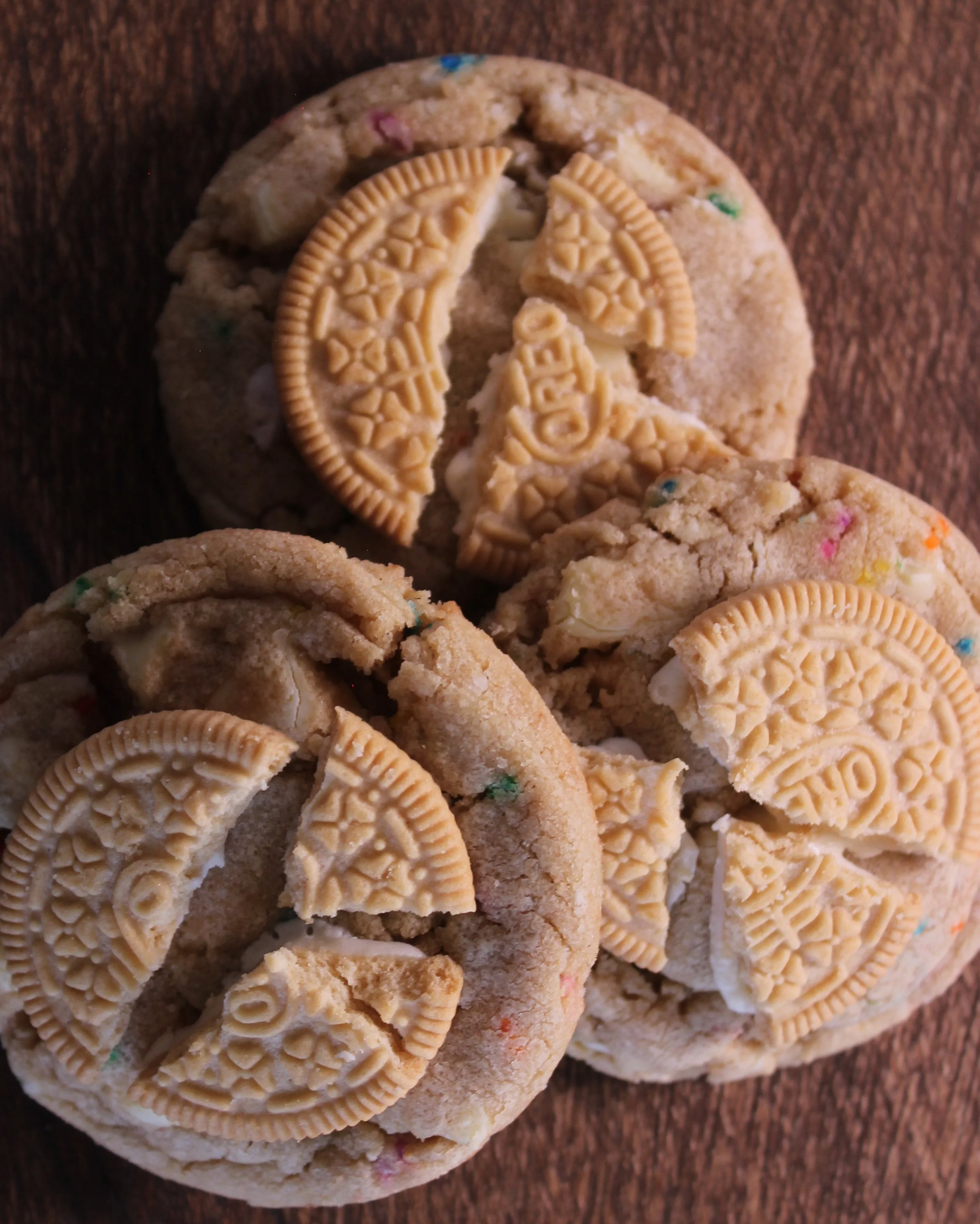 White Chocolate Confetti Cookie: A white callebaut chocolate chip cookie with rainbow sprinkles and topped with a golden Oreo.