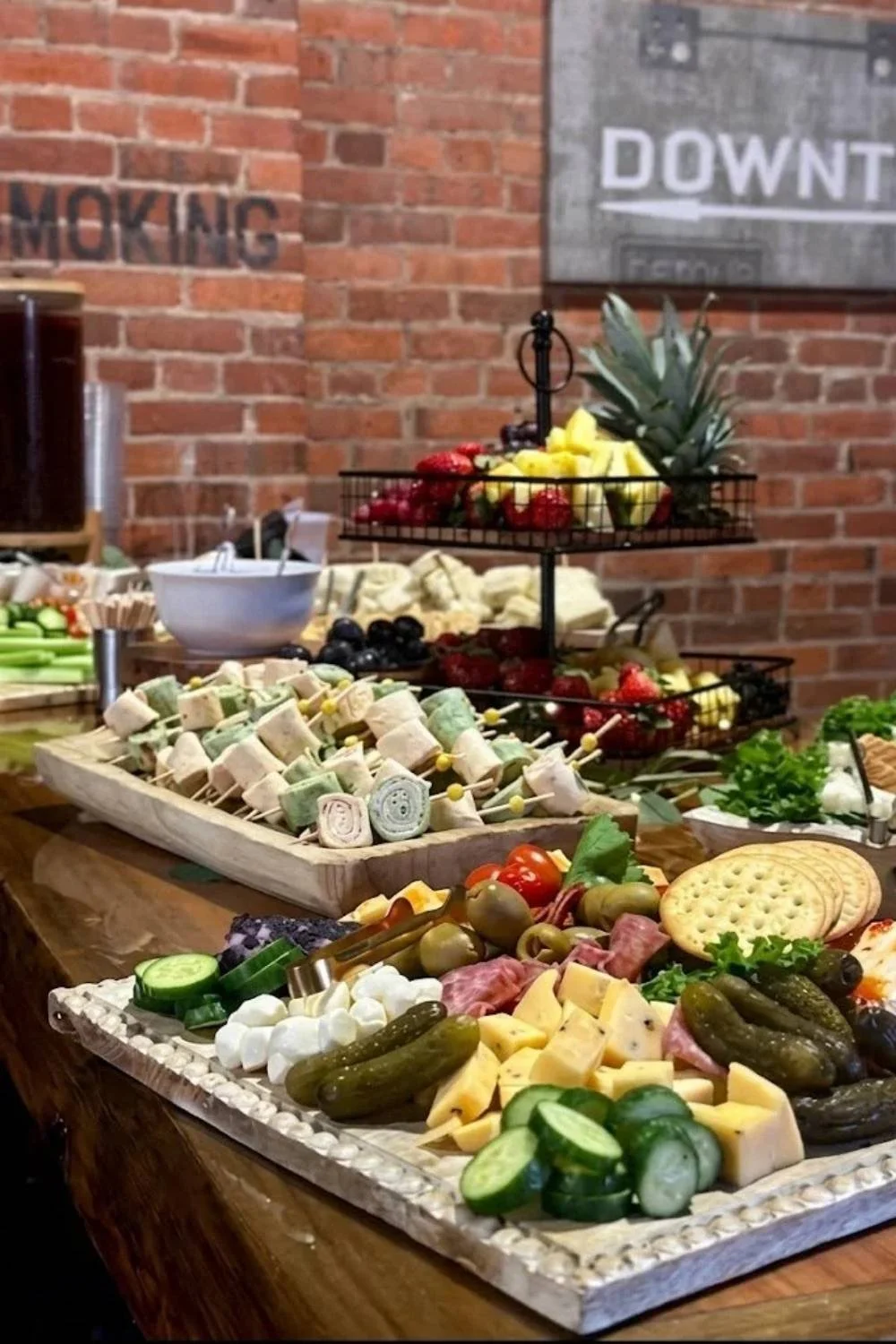 Charcuterie board with meats, cheeses, fruit, and vegetables for a catered event.