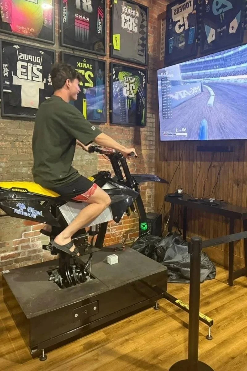 Guest riding a motocross simulator inside the restaurant entertainment area.
