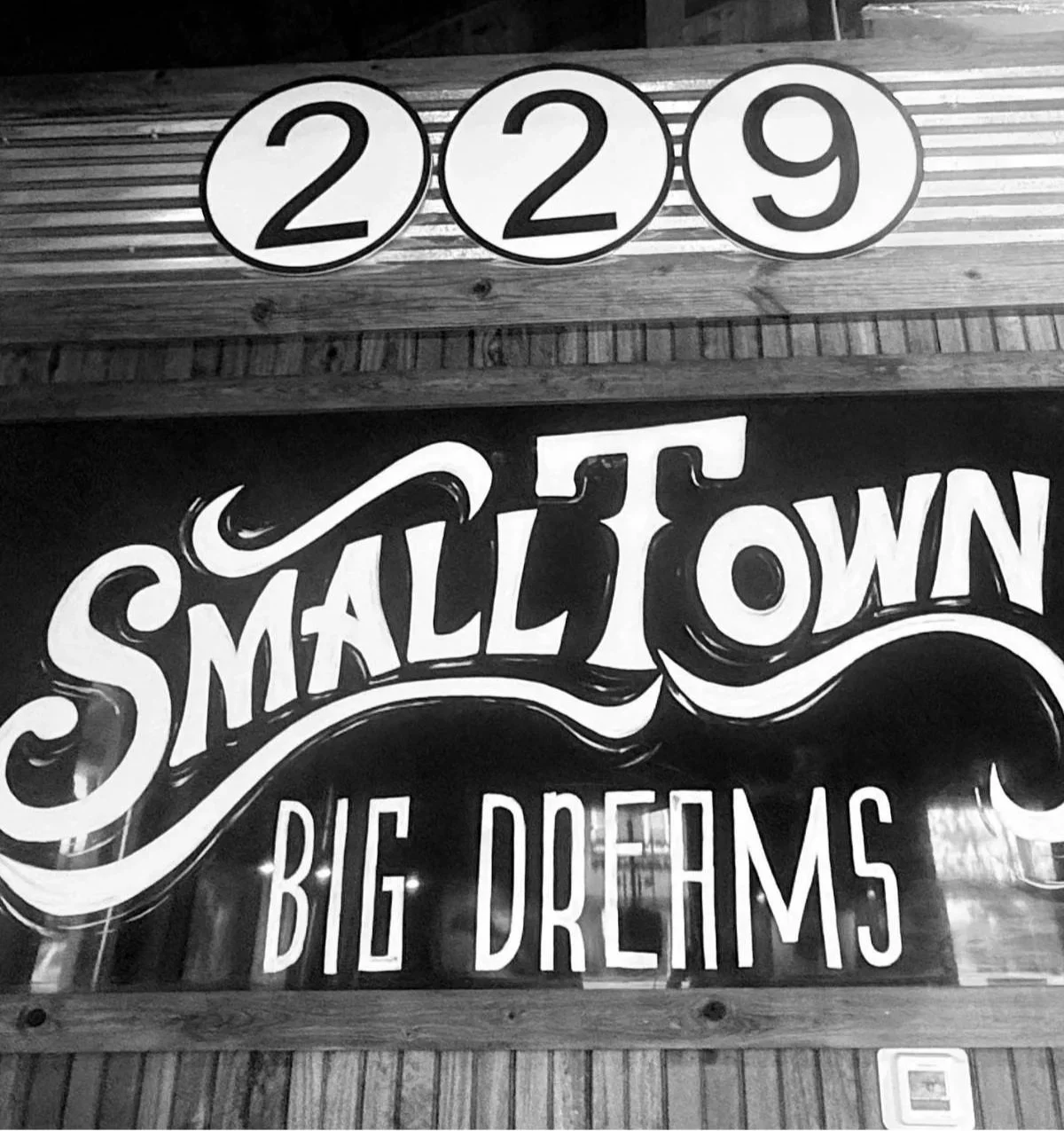 Small Town Big Dreams sign displayed outside a local restaurant storefront.